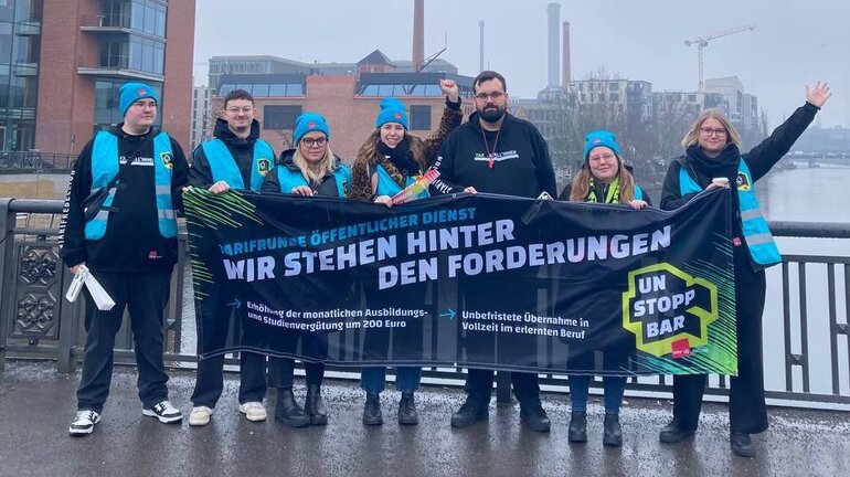 eine Gruppe Personen steht vor der Bundeszentrale der ver.di.