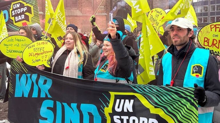 Eine Gruppe Jugendliche trägt Banner und Fahnen, auf denen "Wir sind Unstoppbar" steht.