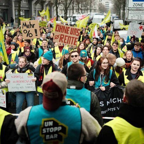 eine große Gruppe Streikende in ver.di Jugend Streikwesten in blau und grün.